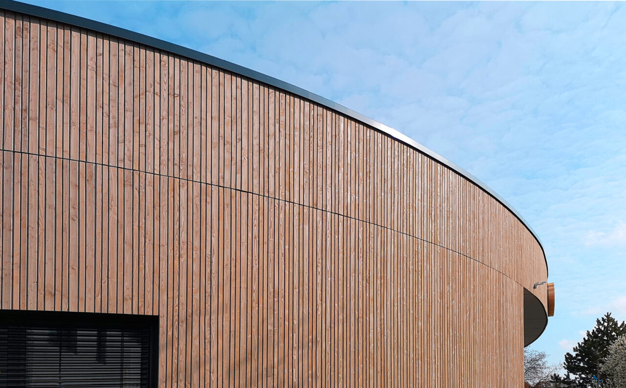 Gebäude mit Holzfassade rund, entworfen und umgesetzt durch das Architekturbüro Die Planschmiede